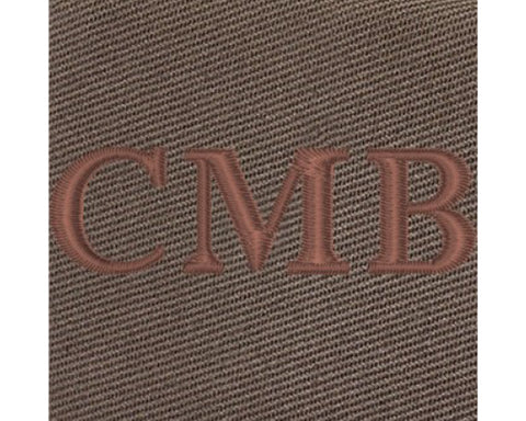The Travis Tote Bag Cotton Twill: Close-up of brown textured fabric with CMB embroidered, showcasing personalized whiskey embroidery on durable, versatile tote.