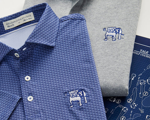 Yale Golf Course Frame Shirt: Navy & White, featuring a small geometric pattern and embroidered bulldog, folded on a schematic map of Yale Golf Course.